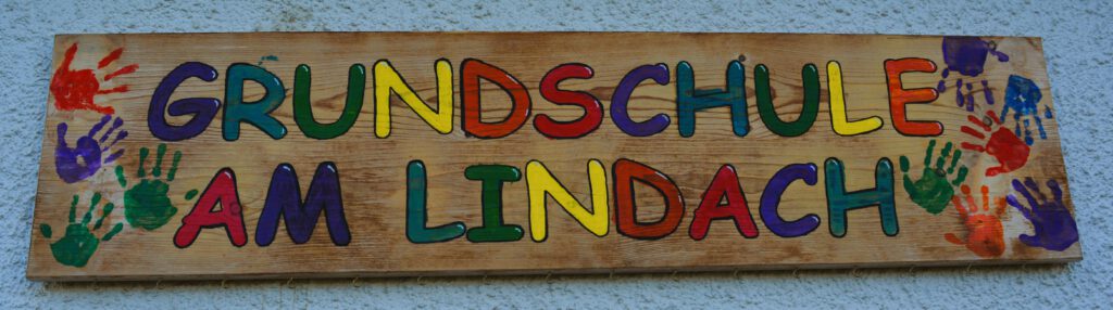 Holzschild mit Aufschrift "Grundschule am Lindach"